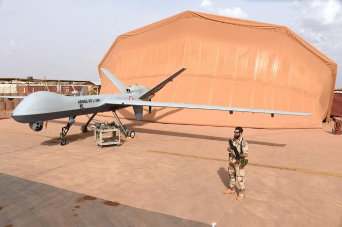 A French soldier involved in the regional anti-insurgent Operation Barkhane stands guard next to a Reaper drone at the French military airbase in Niamey on March 14, 2016. US Reaper drone