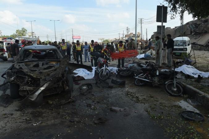 Pakistani rescue workers try to move the bodies of victims at the site of an explosion in Lahore on July 24, 2017. Lahore Blast