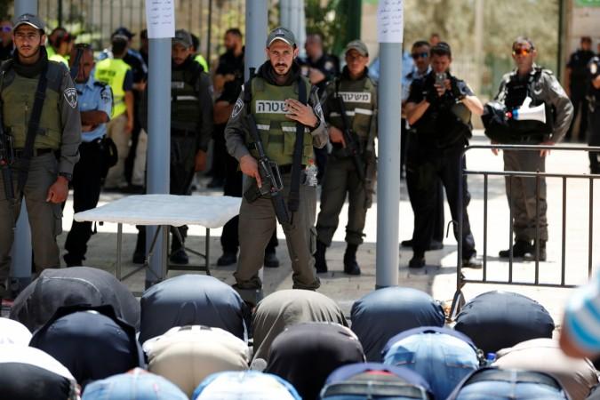 Palestinians pray in front of Israeli policemen and newly installed metal detectors. Israel