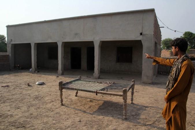 A villager points to the house where a teenage girl was raped in Muzaffarabad, Multan rape