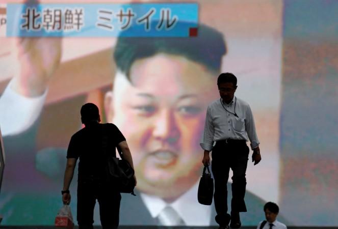 Men walk past a street monitor showing news of North Korea firing a ballistic missile, in Tokyo, Japan, July 4, 2017. North Korea