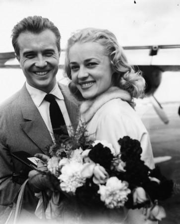 French actors Philippe Lemaire and Jeanne Moreau getting ready to leave England following the premiere of their film 'The Parasites', London Airport, July 6th 1956. Jeanne Moreau