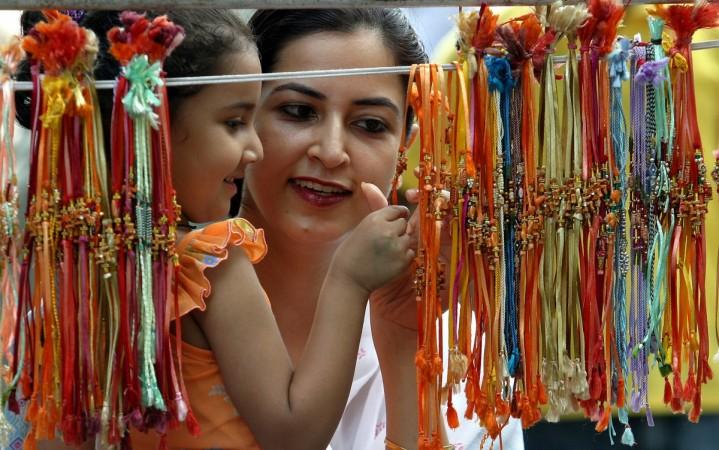 A woman and daughter look at traditional Indian threads known as rakhis at a market in Chandigarh. Raksha Bandhan 2017, Rakhi 2017
