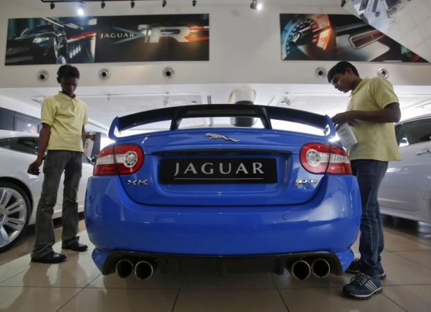 Showroom attendants polish a Jaguar vehicle at a Jaguar Land Rover showroom in Mumbai February 13, 2013. Hit by falling margins and rising capital expenditure, roaring Jaguar Land Rover (JLR) may be heading for a speed trap. Rising investment is eating into the luxury carmaker's cash pile and raising the prospect of fresh borrowing, while falling profitability is set to tip parent Tata Motors into a first drop in profits in five quarters. Picture taken February 13, 2013. REUTERS/Vivek Prakash (INDIA - Tags: BUSINESS TRANSPORT) Tata Motors