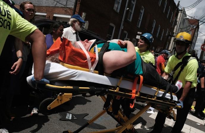 Rescue workers transport a victim who was injured when a car drove through a group of counter protesters at the
