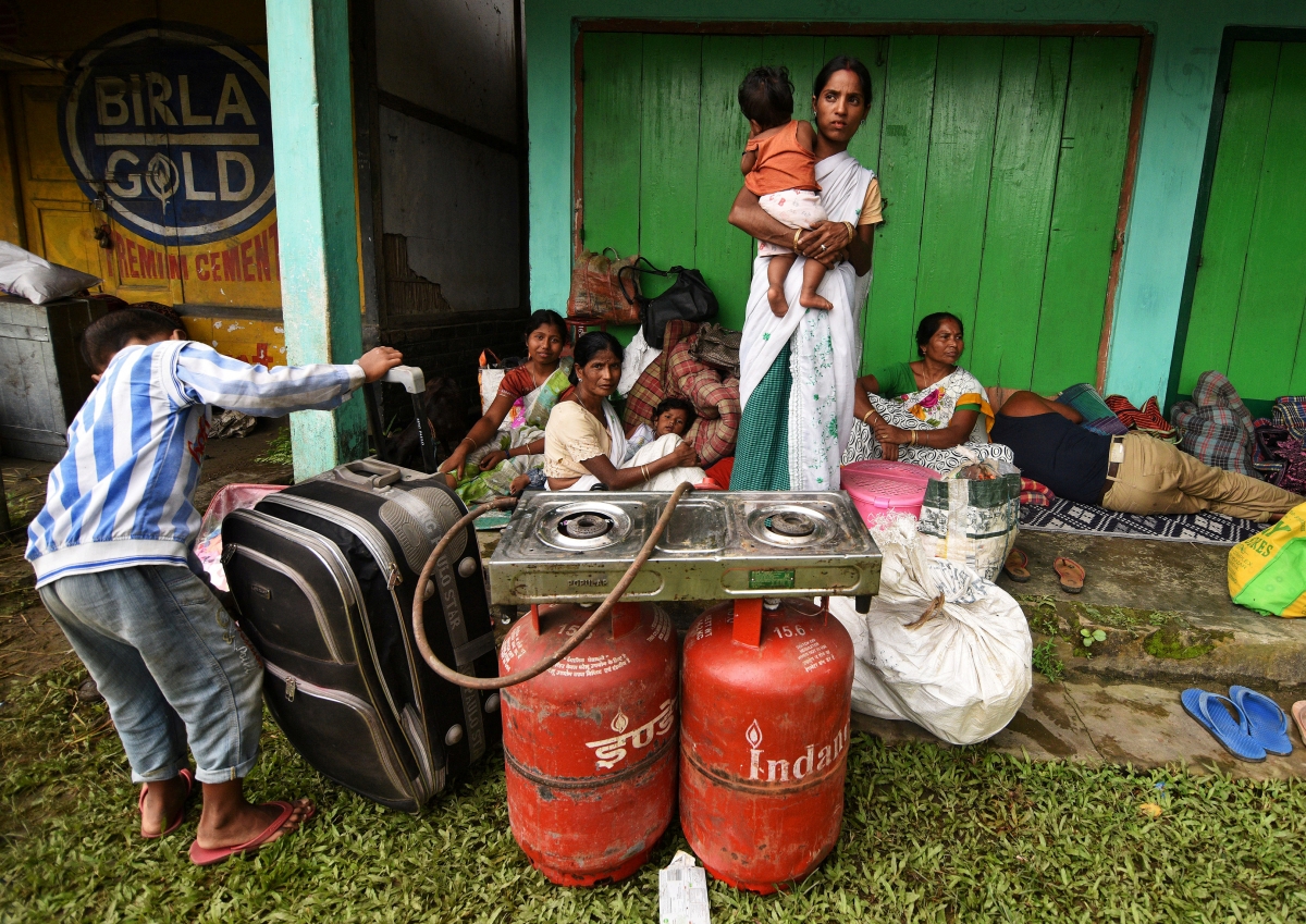 Flood affected families take shelter in front of a shop and wait for relief material in Jakhalabandha area in Nagaon district, in the northeastern state of Assam, on August 13, 2017. Assam flood