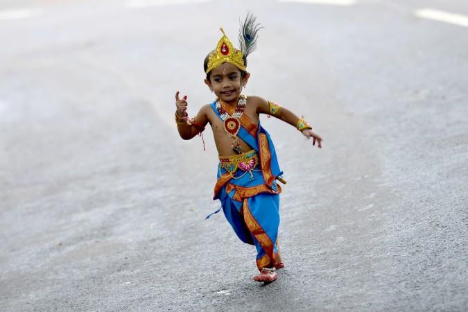 A child dressed as the Hindu deity Krishna runs around after an enactment competition as part of Krishna Janmashtami celebrations in Bangalore on August 12, 2017. Krishna Janmashtami