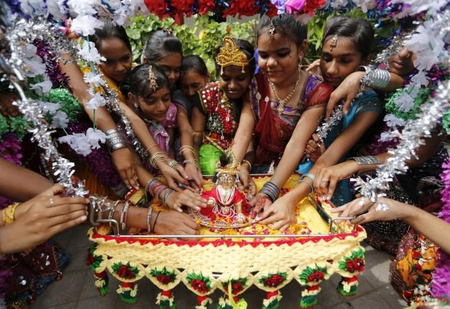 Students spin an idol of Hindu Lord Krishna during celebrations marking the Janmashtami festival Krishna Janmashtami