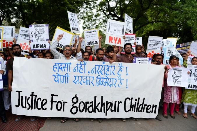 Activists and Indian students hold placards as they shout slogans during a protest rally against the recent death of at least 64 children at a government hospital in northern India that suffered oxygen shortages, in New Delhi on August 13, 2017. Gorakhpur