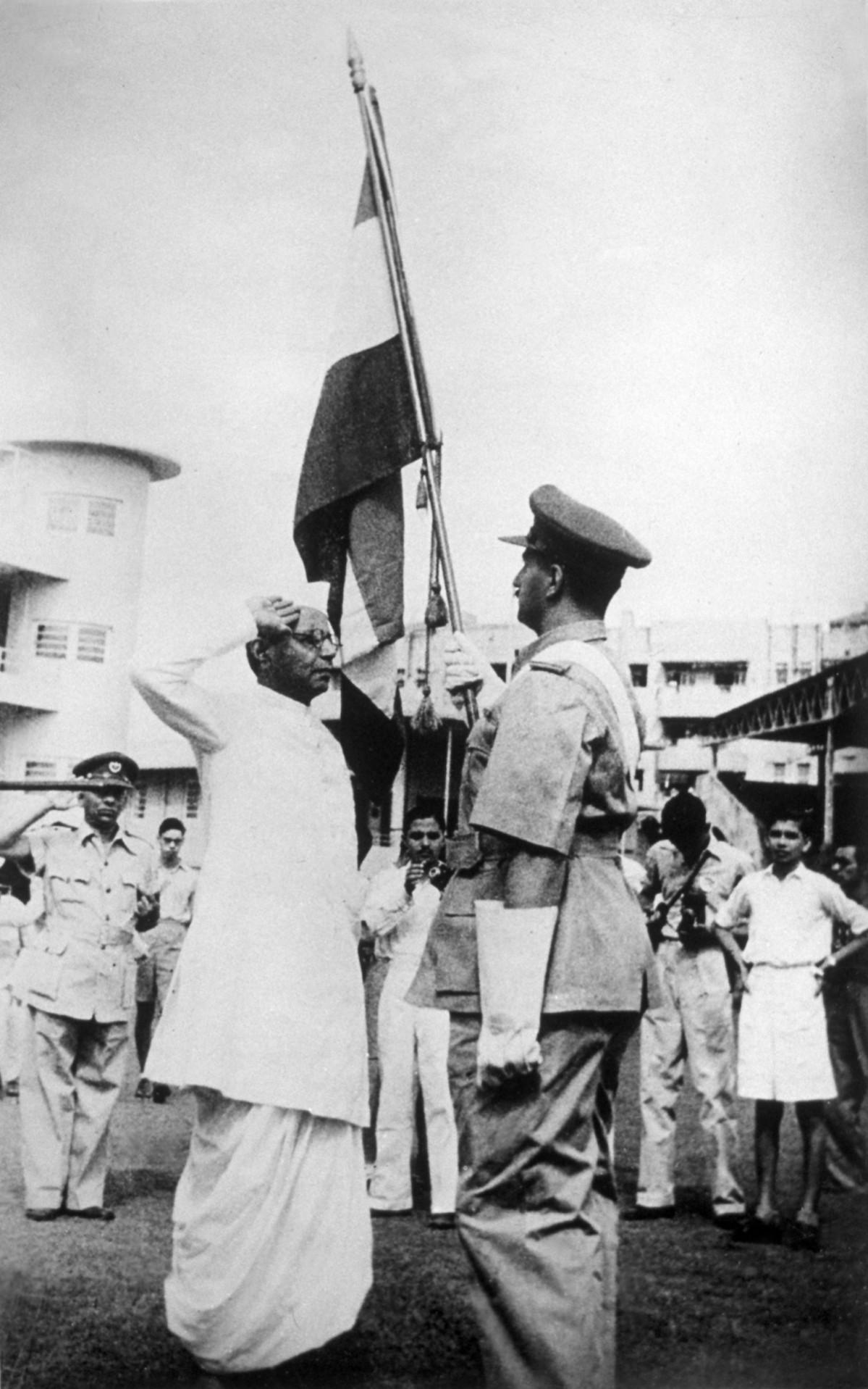 The presentation of colours to the Bombay Home Guard, part of the celebrations of Indian Independence Day at Bombay. B G Kher, Bombay Premier, salutes the flag. India's Independence