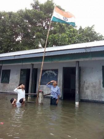 People, including students and teacher, in Assam celebrate Independence Day despite being surrounded in waist-deep waters. Assam Independence Day