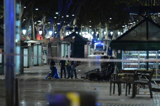 Policemen check the area after towing away the van which ploughed into the crowd, killing at least 13 people and injuring around 100 others on the Rambla in Barcelona, on August 18, 2017. Barcelona attack