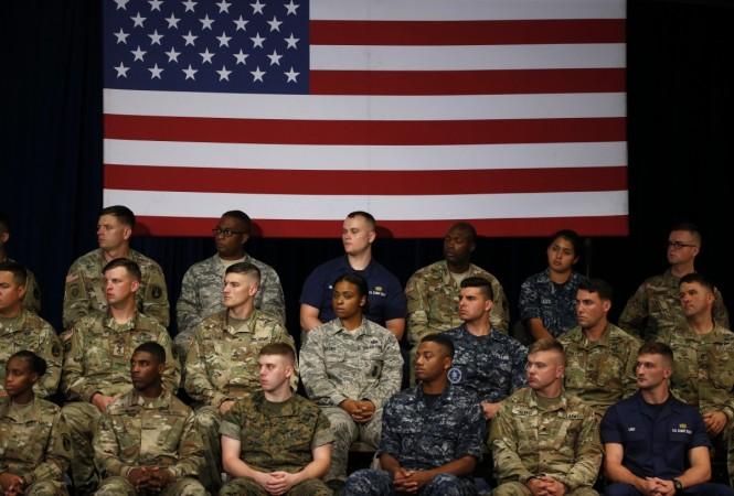 Military members watch as U.S. President Trump announces his new policy for the war in Afghanistan at Fort Meyer, Virginia Trump