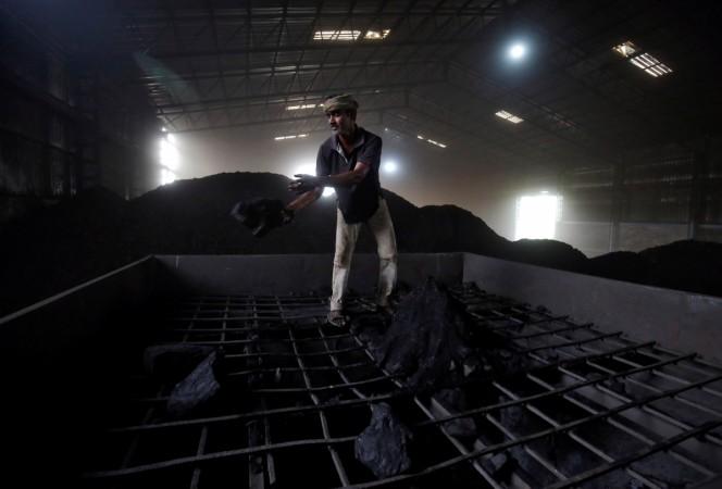 A labourer works inside a coal yard on the outskirts of Ahmedabad, India, April 6, 2017 Coal