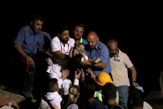 Italian Carabinieri police officer and a doctor carry a child after an earthquake hit the island of Ischia, off the coast of Naples, Italy August 22, 2017. Italy Earthquake