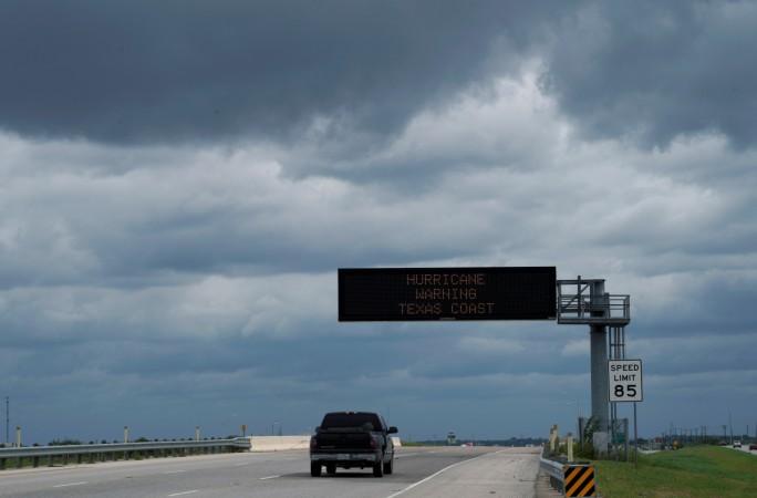 A vehicle passes a hurricane warning sign under storm clouds as it heads south approaching Victoria, Texas, U.S. August 25, 2017 Hurricane Harvey