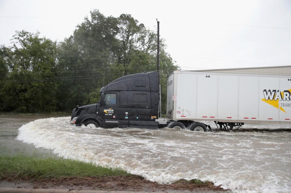 A truck navigates a road flooded with rain water, remnants of Hurricane Harvey, on August 28, 2017 in Houston, Houston floods
