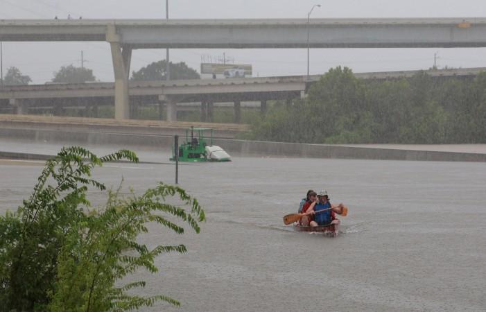 Area residents use a kayak to rescue motorists stranded on Interstate highway 45 which is submerged from the effects of Hurricane Harvey seen during widespread flooding in Houston Houston floods