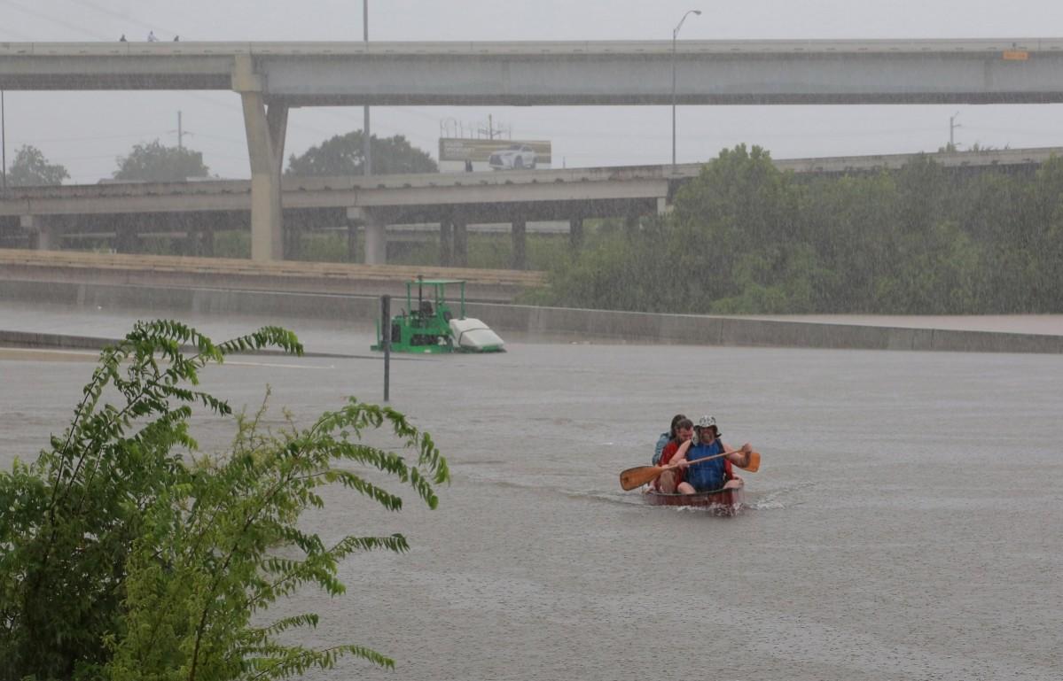 Area residents use a kayak to rescue motorists stranded on Interstate highway 45 which is submerged from the effects of Hurricane Harvey seen during widespread flooding in Houston Houston floods