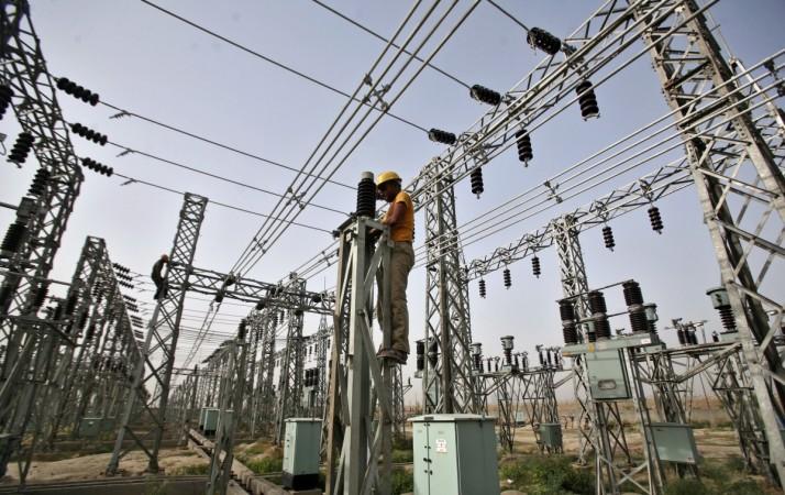 An employee works on electric pylons at a power station in Greater Noida on the outskirts of New Delhi on June 8, 2012. NTPC