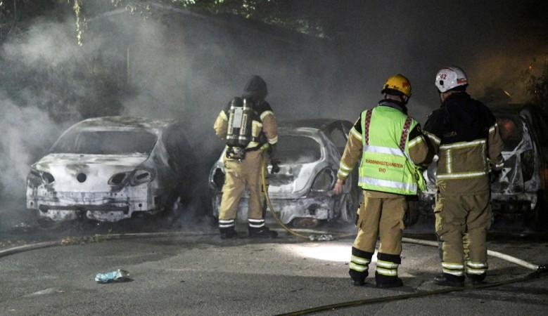 Firefighters extinguish a fire which had damaged cars after the vehicles had been set alight, in Malmo, Sweden Sweden