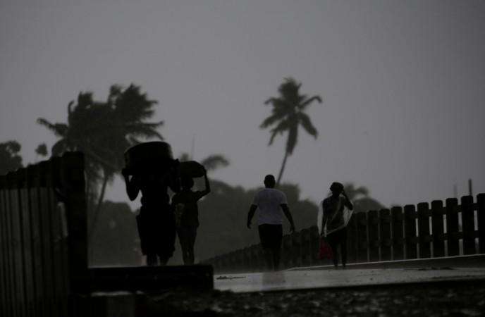 People walk across a bridge in the rain brought by Hurricane Irma in Cap-Haitien, Haiti, Irma