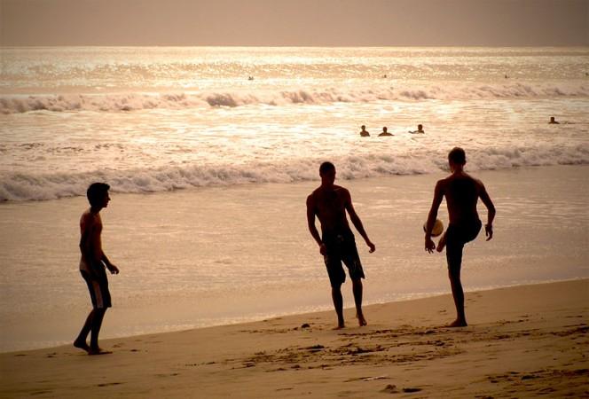 Tourists taking a swim in the sea at dusk. goa beach