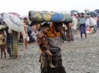 Rohingya refugees walk in the rain as they are held by the Border Guard Bangladesh (BGB) after illegally crossing the border, in Teknaf, Bangladesh.