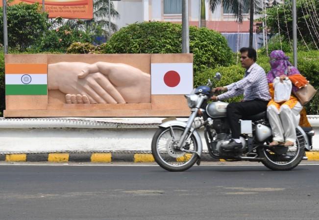 ndian commuters drive past a display of the Japanese and Indian national flags ahead of a visit by Japanese Prime Minister Shinzo Abe in Ahmedabad on September 13, 2017. India's premier Narendra Modi and Japanese counterpart Shinzo Abe are preparing to break ground on India's first bullet train project September 14, during an official visit to India by the Japanese prime minister. Shinzo Abe Modi Gujarat