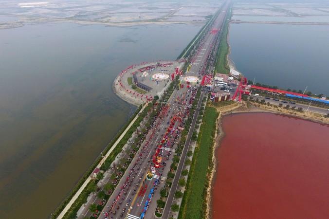 A salt lake which is separated by a road, shows parts of it in different colours due to algae, in Yuncheng, Shanxi Province, China, September 25, 2016. Dead Sea in China