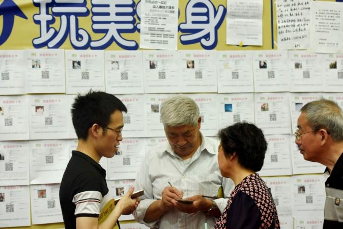 This photo taken on May 14, 2017 shows people exchanging contact information during a matchmaking event in Hangzhou, eastern China's Zhejiang province. China blind date