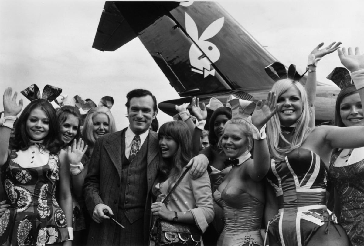 Hugh Hefner, American editor, publisher and founder of Playboy magazine, and his girlfriend Barbi Benton are welcomed by 'Bunny Girls' from the London Playboy Club, on their arrival at Heathrow Airport aboard his private DC 9 jetliner, which bears the Playboy logo. Hugh Hefner