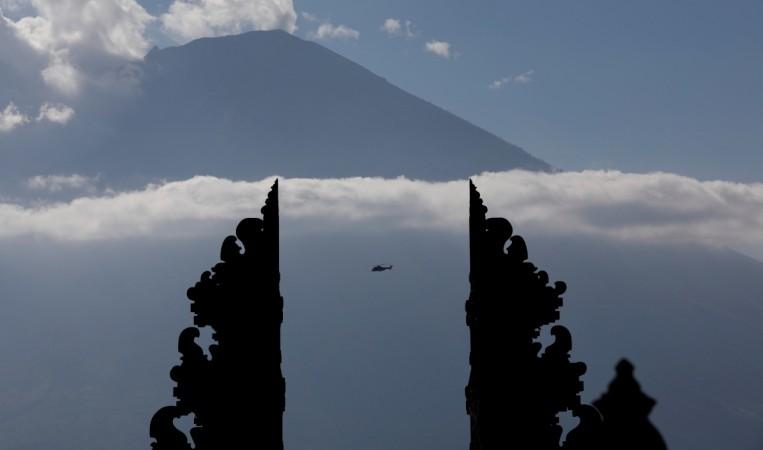 A helicopter, one of three carrying officials including President Joko Widodo, is seen flying near Mount Agung, a volcano on the highest alert level. Mount Agung