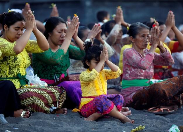 Balinese pray for safety on the beach near Mount Agung, a volcano on the highest alert level, outside the current danger zone in Amed, on the resort island of Bali, Indonesia, September 27, 2017. Mount Agung