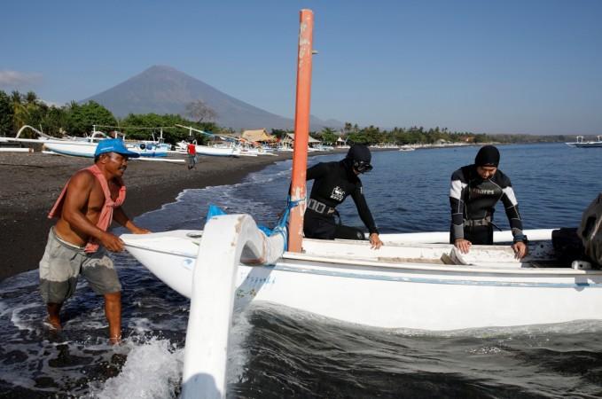 Mount Agung, a volcano on the highest alert level, is seen as tourists from China depart for a dive in Amed. Mount Agung