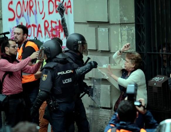 A woman is grabbed by riot police near a a polling station for the banned independence referendum in Barcelona. Catalonia referendum