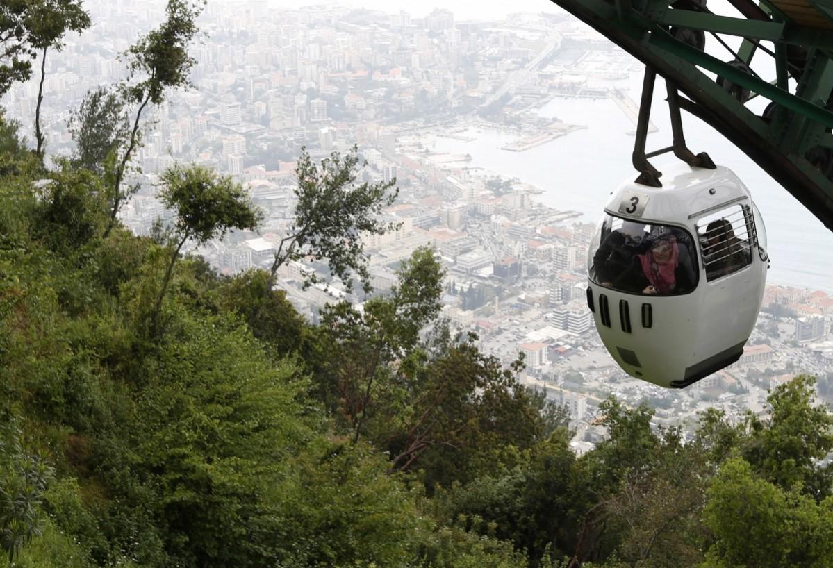 Tourists sit in a cable car from Harisa into Jounieh in northern Beirut April 18, 2013.A new Lebanese government's best hope of rebooting its battered economy may lie in efforts to persuade wealthy Gulf Arab tourists to return after a boycott last year, but it is a gargantuan task. Beirut