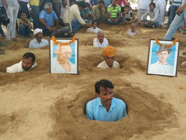 Rajasthan farmers buries in neck-deep mud. rajasthan farmers
