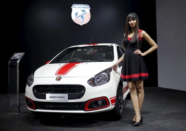 A model poses next to a Fiat Abarth car on display at the Indian Auto Expo in Greater Noida, on the outskirts of New Delhi, India, February 3, 2016 Auto Expo