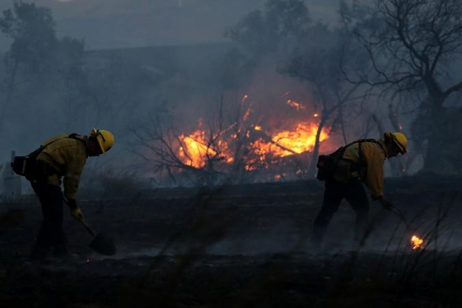 Firefighters work to put out hot spots on a fast moving wind driven wildfire in Orange, California, U.S., October 9, 2017 California