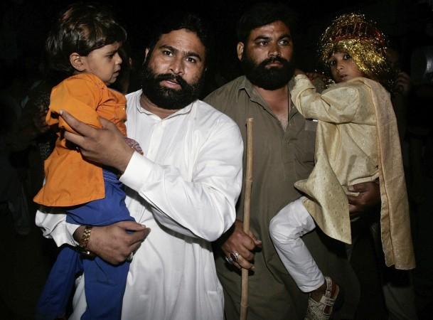 Seven-year-old groom Mohammad Waseem (R) and his four-year-old bride Nisha (L) are escorted by security officials at a police station in Karachi October 31, 2008. Pakistani police raided a child marriage ceremony in the city of Karachi and arrested a cleric who was presiding over the wedding of a 4-year-old girl and a 7-year-old boy. child marriage in pakistan