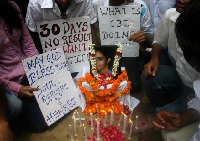 Indian schoolchildren gather with placards and lighted candles around a picture of slain classmate Aarushi Talwar during a rally in New Delhi on June 20, 2008, to demand in inquiry into her death. Arushi 2
