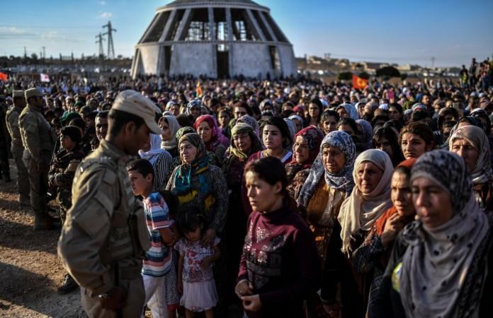 A picture taken on October 14, 2017 in the Kurdish town of Kobane in northern Syria shows people gathering and mourning during the funeral of a Kurdish fighter, who was killed in clashes against Islamic State (IS) group fighters in the city of Deir Ezzor. syria, kurdish forces