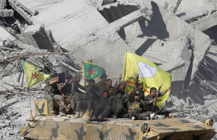 In picture: Syrian Democratic Forces (SDF) fighters ride atop of military vehicle as they celebrate victory in Raqqa, Syria, October 17, 2017. Raqqa