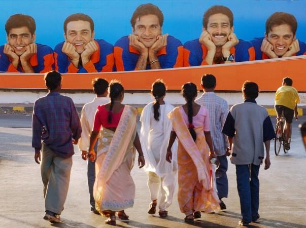 Indian cricketers (L to R) Ajay Ratra, Virender Sehwag, Javagal Srinath, Anil Kumble and Rahul Dravid stare down from an advertisement at pedestrians walking on the streets of Bombay February 9, 2003. Virender Sehwag Javagal Srinath Anil Kumble