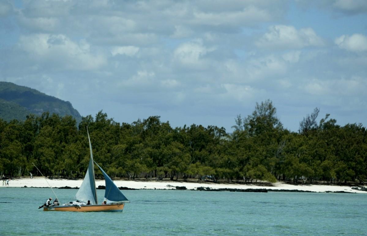 A small fishing boat cruises along the East coast of Mauritius near Ile aux Cerfs which has one of the most picturesque and spectacular beaches on the Indian Ocean island. Mauritius