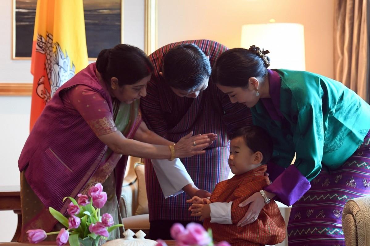 Indian Foreign Minister Sushma Swaraj (L) gives her blessings to Bhutan's prince Jigme Namgyel Wangchuck (C) as Bhutans King Jigme Khesar Namgyel Wangchuck (2R) and Queen Jetsun Pema (R) look on prior to a meeting in New Delhi on November 1, 2017. Bhutanese King Jigme Khesar Namgyel Wangchuck