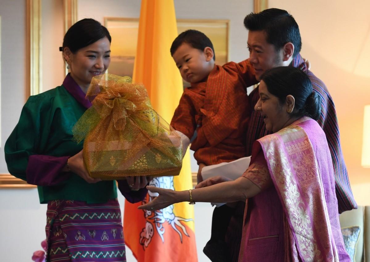 Indian Foreign Minister Sushma Swaraj (R) presents gifts to Bhutans King Jigme Khesar Namgyel Wangchuck (2R) as Queen Jetsun Pema (L) and prince Jigme Namgyel Wangchuck (C) look on prior to a meeting in New Delhi on November 1, 2017. Bhutanese King Jigme Khesar Namgyel Wangchuck