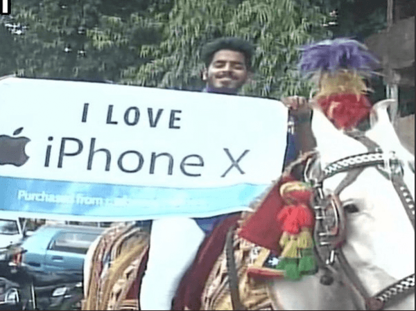 Mahesh Paliwal seen holding the placard that reads, iPhone X India