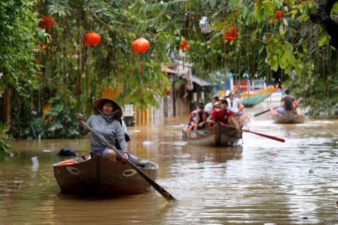 People ride boats past houses submerged by Typhoon Damrey in the UNESCO heritage ancient town of Hoi An, Vietnam Vietnam